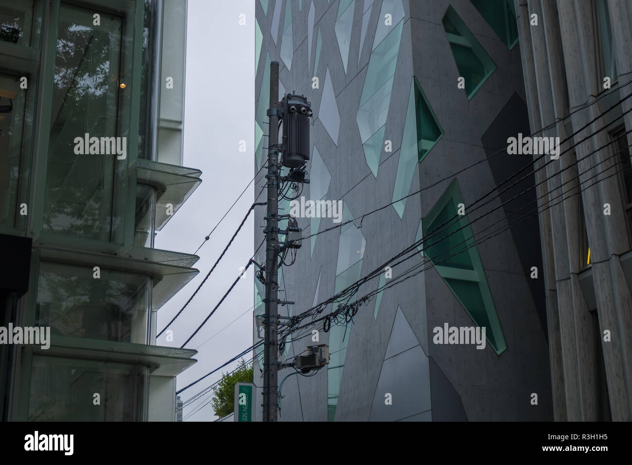 Le linee di alimentazione passa da un architettura moderna a Tokyo in Giappone. Foto Stock