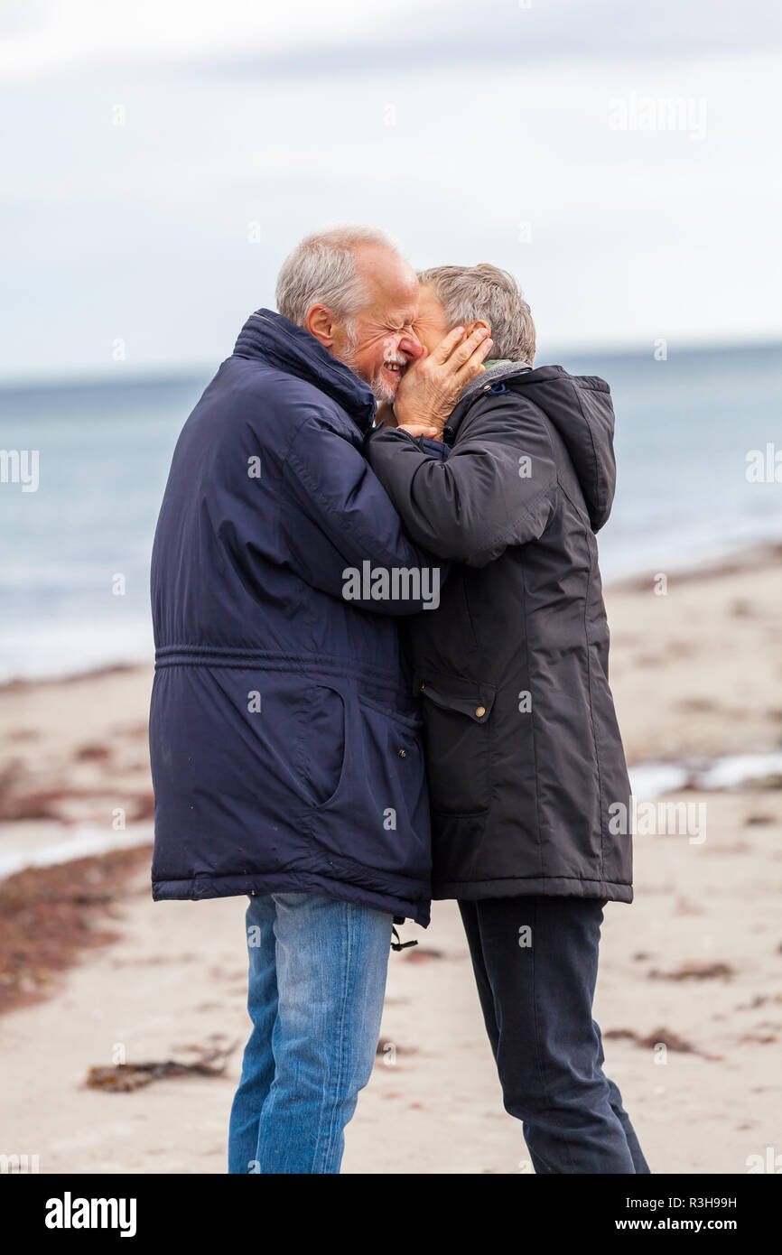 Senior adulto felice coppia è di camminare sulla spiaggia Foto Stock