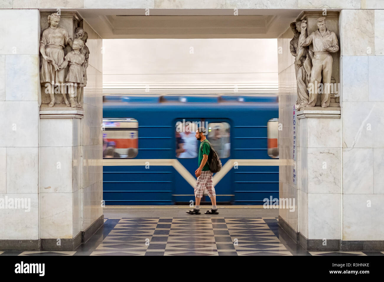 Lonely Man sulla piattaforma, Narvskaya stazione della metropolitana a San Pietroburgo, Russia. Sculture intorno a. Foto Stock