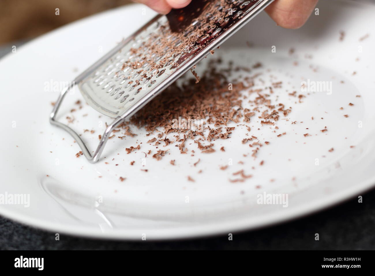 Grattugiare il cioccolato Bar utilizzando Palmare grattugia. Rendendo  Boston Banoffee Pie Foto stock - Alamy