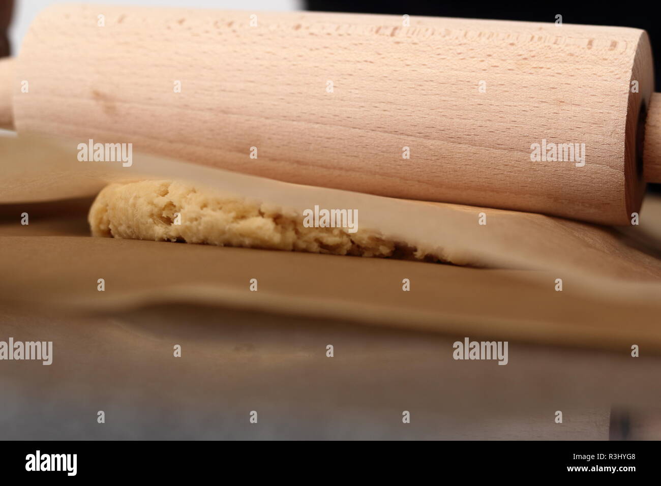 Il roll out pasta tra due fogli di carta da forno . Rendendo il sidro di mele serie a torta. Foto Stock