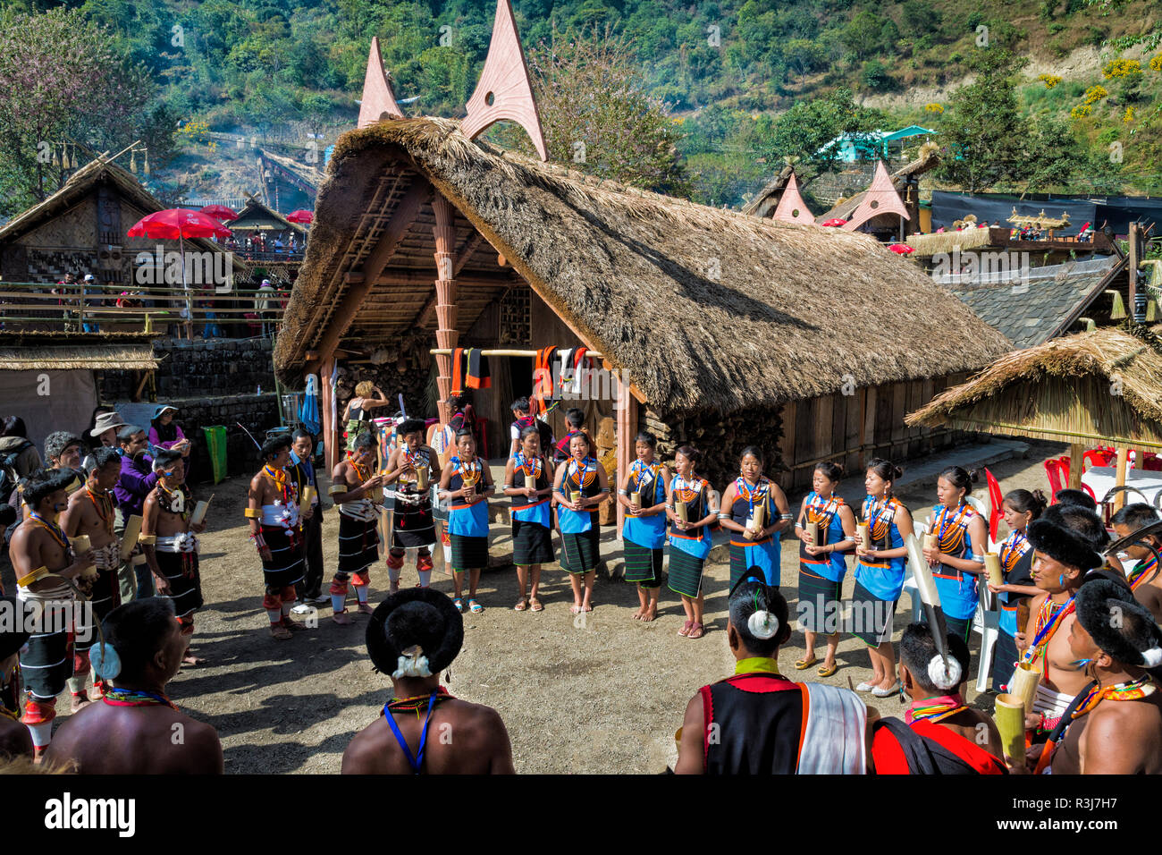 Naga tribù di persone davanti a una casa tradizionale Kisima Nagaland Hornbill festival, Kohima, Nagaland, India Foto Stock