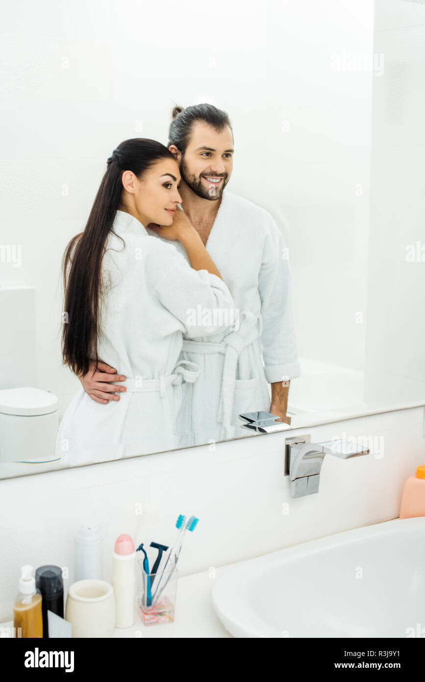 Tenera coppia di accappatoi bianchi abbracciando in bagno al mattino Foto  stock - Alamy