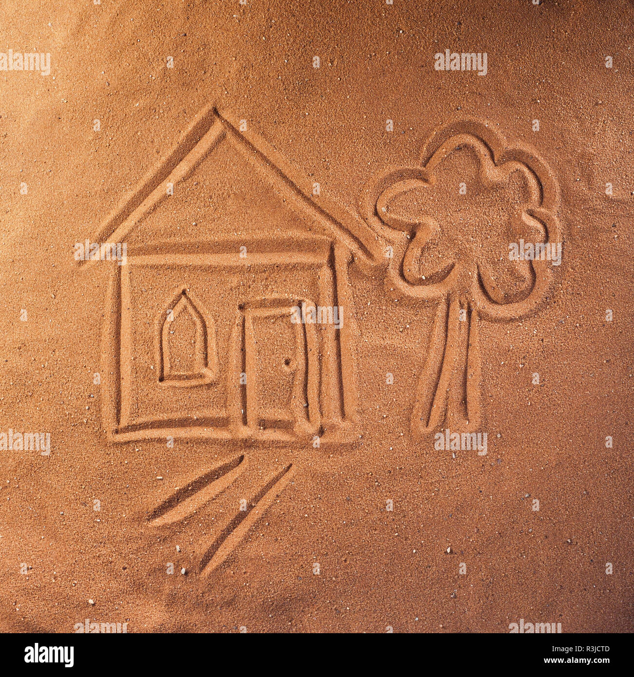 Disegno sulla sabbia di una casa e un albero Foto Stock