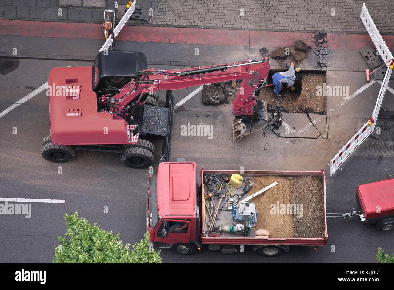 Strada in costruzione sito con escavatore e lavoratori Foto Stock