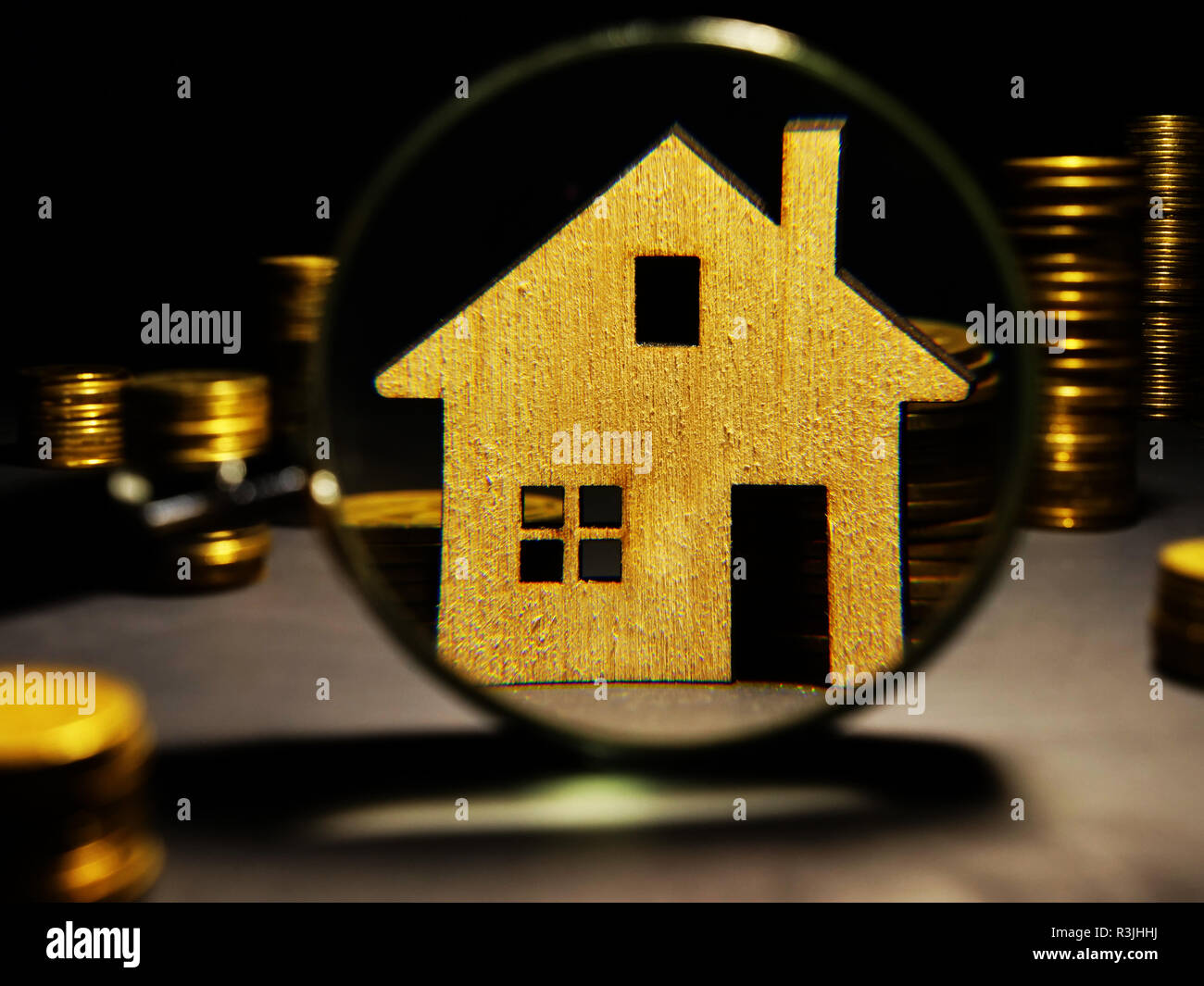 Lente di ingrandimento e il modello della casa. Gli investimenti immobiliari di valutazione. Foto Stock