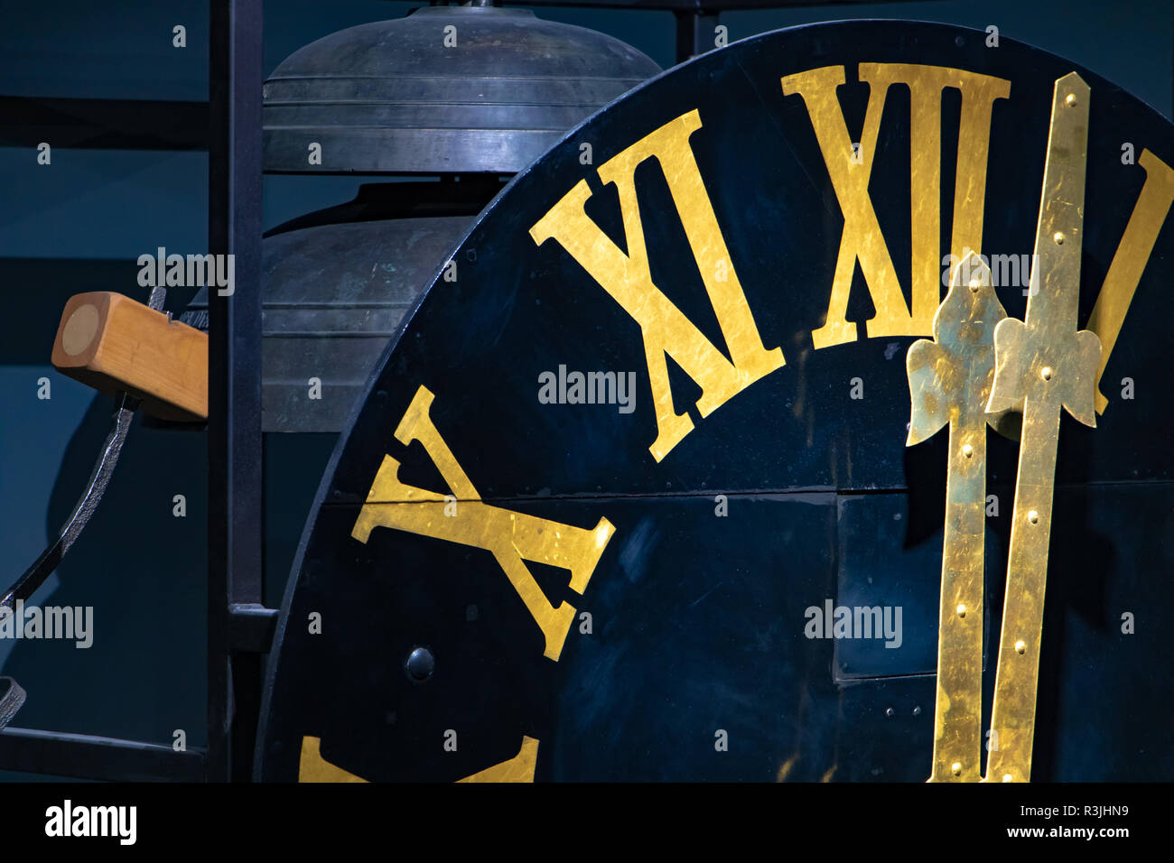 L'orologio dorato con numeri romani mostra dodici ore. La mezzanotte sulla  torre dell'orologio. Meccanismo di orologio con il martello e le campane  Foto stock - Alamy