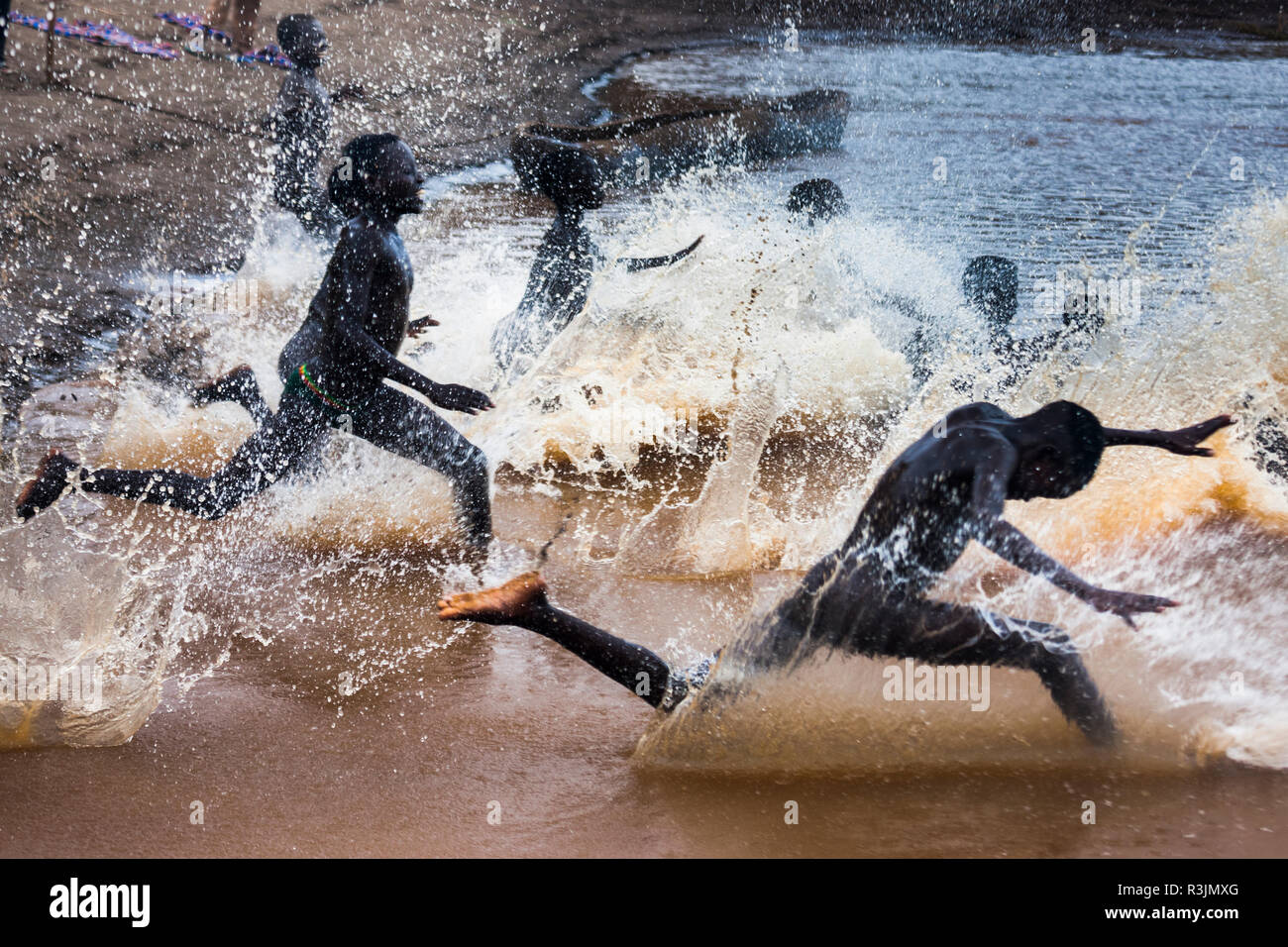 I ragazzi corrono al fiume Omo, Etiopia Foto Stock