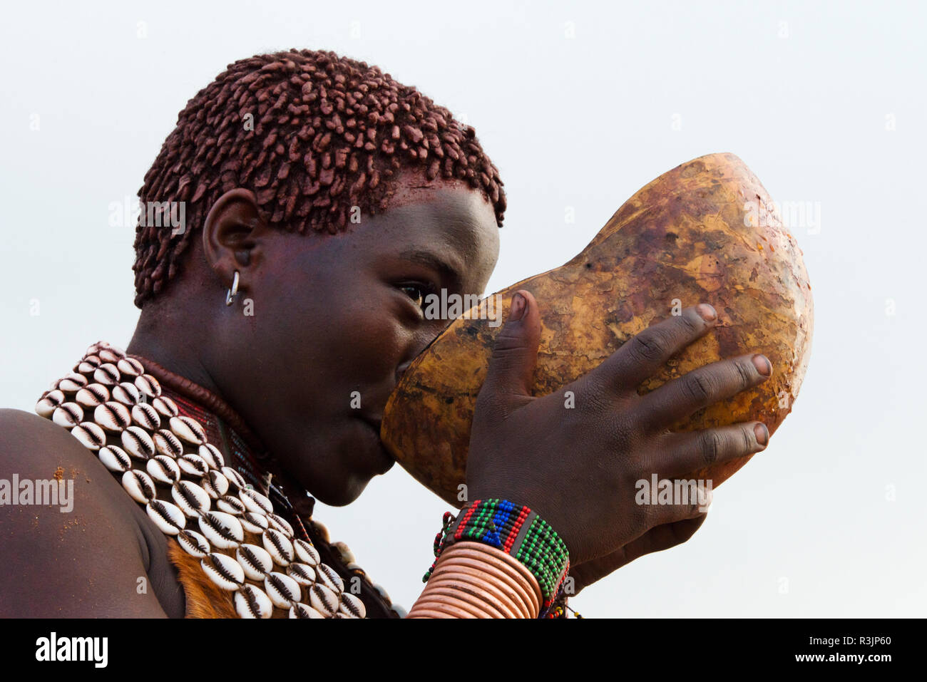 Hamar tribù, persone in abiti tradizionali di bere vino, Hamar Village, Sud Omo, Etiopia Foto Stock