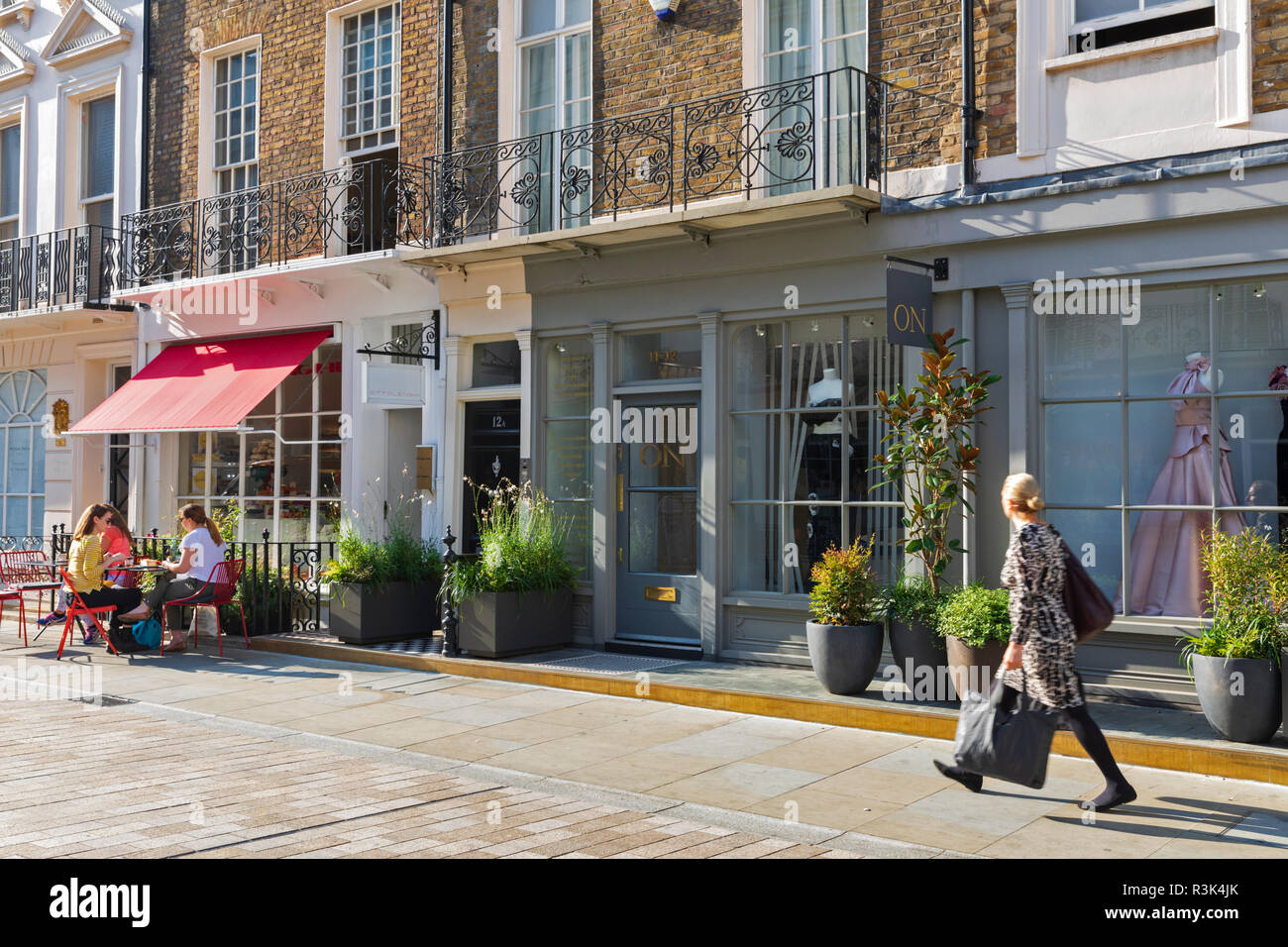 Una donna che cammina verso la Ottolenghi Deli su Motcomb Street nel quartiere di Belgravia a Londra, Inghilterra, Regno Unito. Foto Stock