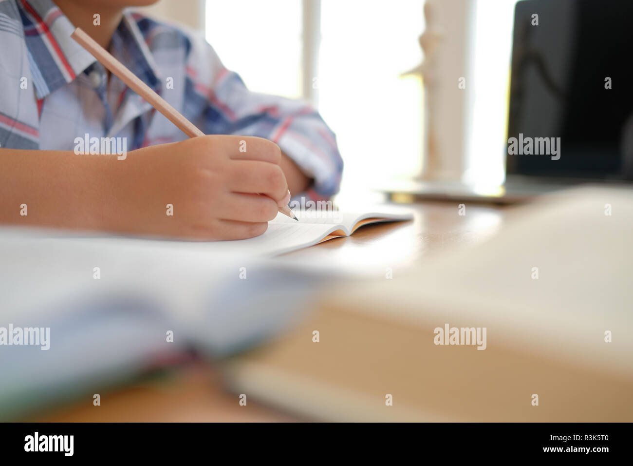 Giovane poco asian kid boy schoolboy iscritto il disegno sul notebook. bambini a fare i compiti. infanzia formazione Foto Stock