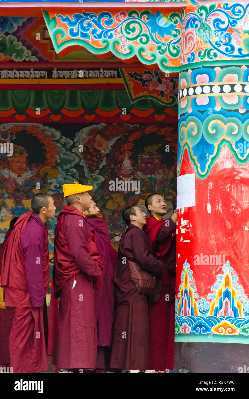 Gli studenti guardando il bollettino pubblicato su colonna a Seda Larung Wuming, il più grande del mondo Buddista Tibetana Institute, garze, nella provincia di Sichuan, in Cina Foto Stock