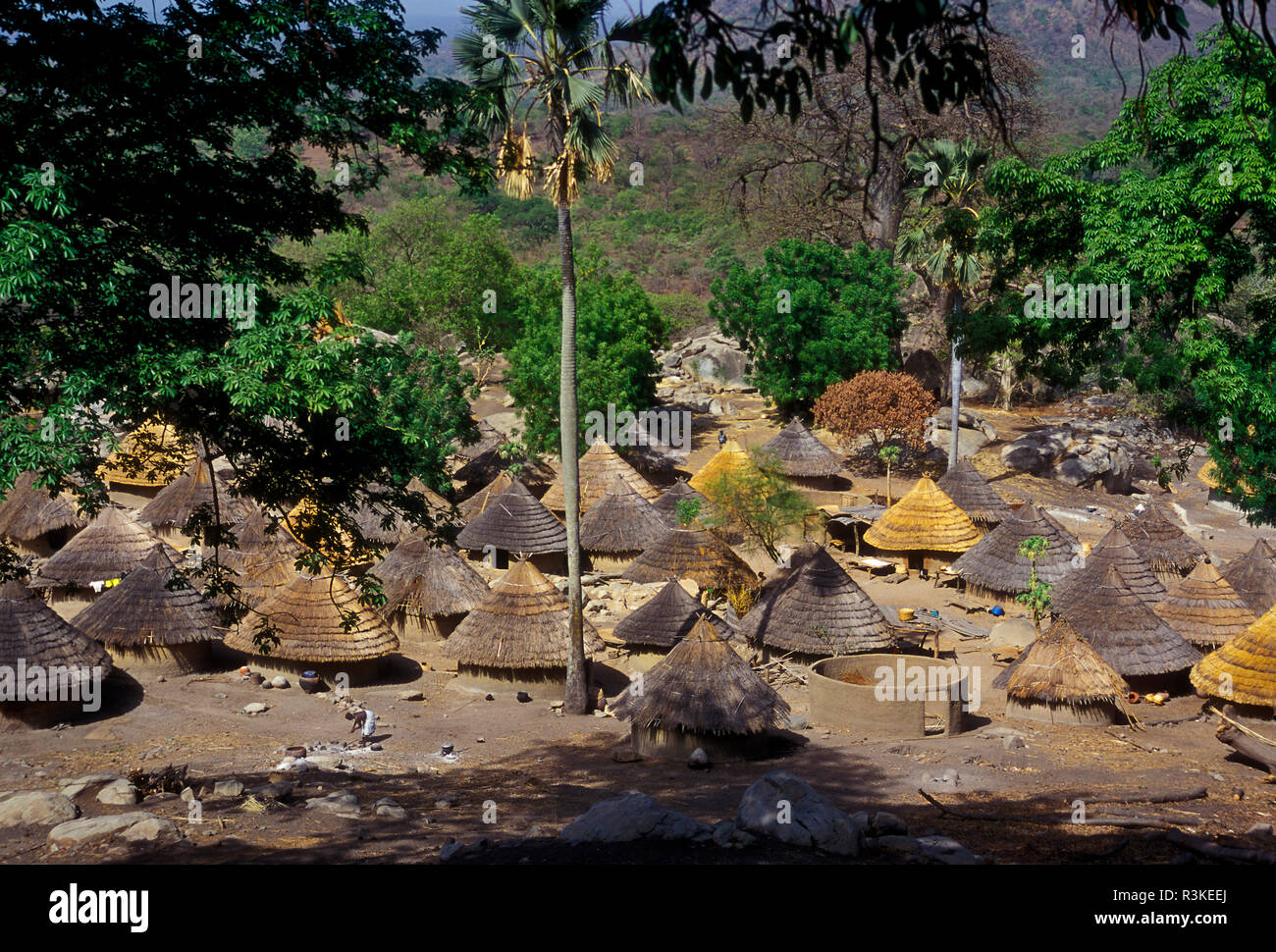 Africa sub-sahariana, Senegal. Una collina vista dell'erba-case dal tetto di una tribù Bedik village. Foto Stock