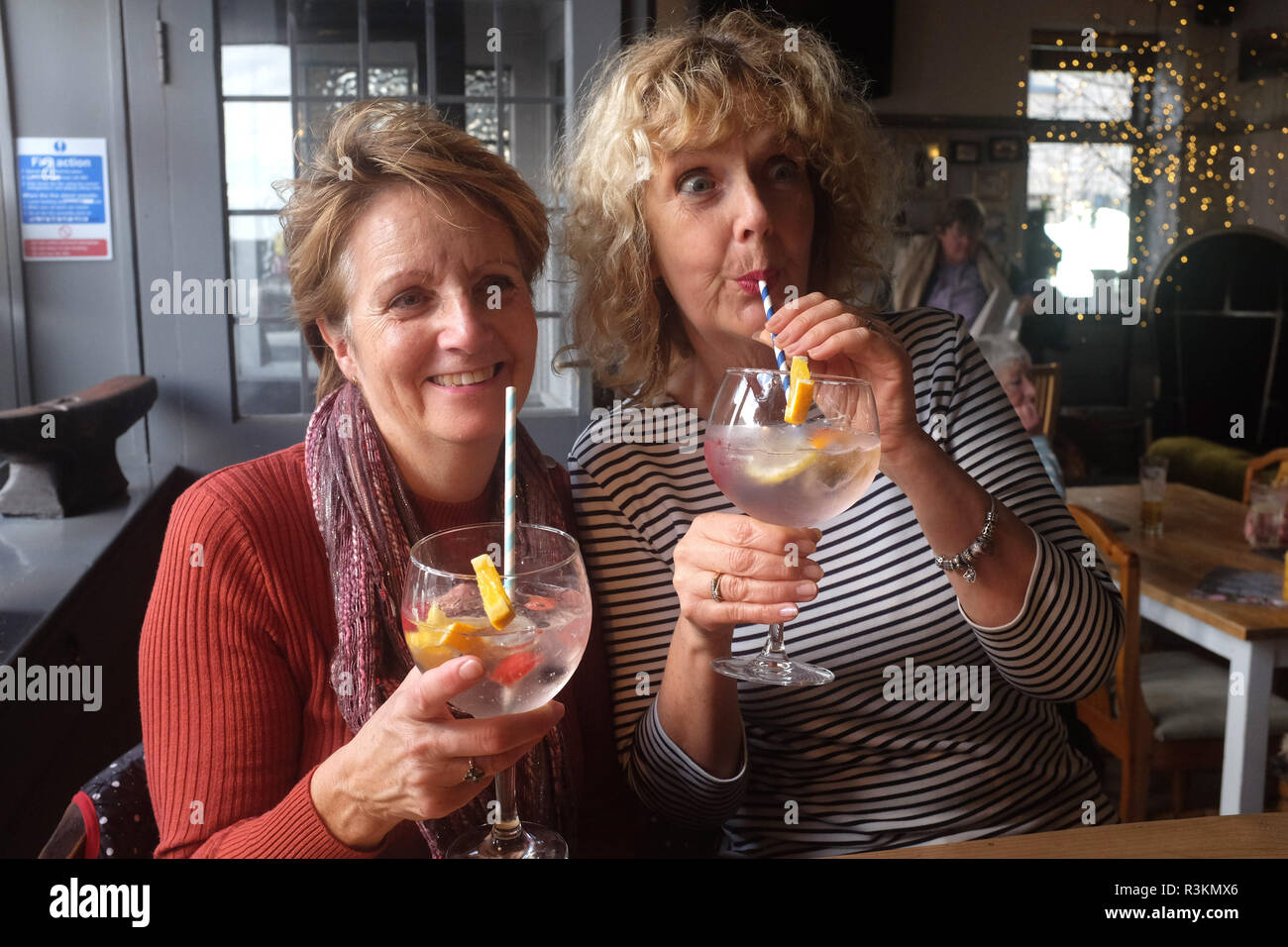 Le donne di bere una grande gin tonic con carta cannucce REGNO UNITO Foto Stock