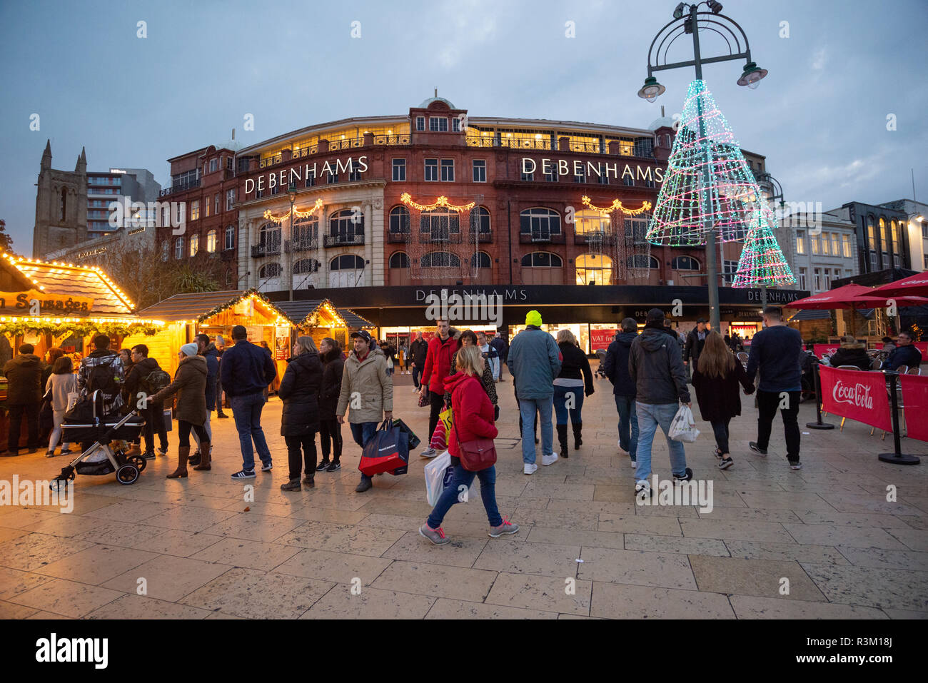 Gli acquirenti del Black Friday nella piazza fuori dal grande magazzino Debenhams, con un mercatino di Natale e una scena festosa nel centro commerciale della città, Bournemouth, Dorset, Inghilterra, Regno Unito, Novembre 2018. Foto Stock