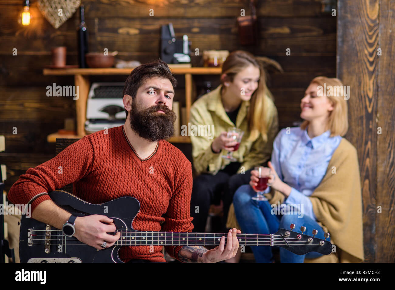 Uomo con barba elegante godendo di processo creativo. Musicista divertente la moglie e la figlia. Ragazze con volto sorridente ascoltando musica, felicità c Foto Stock