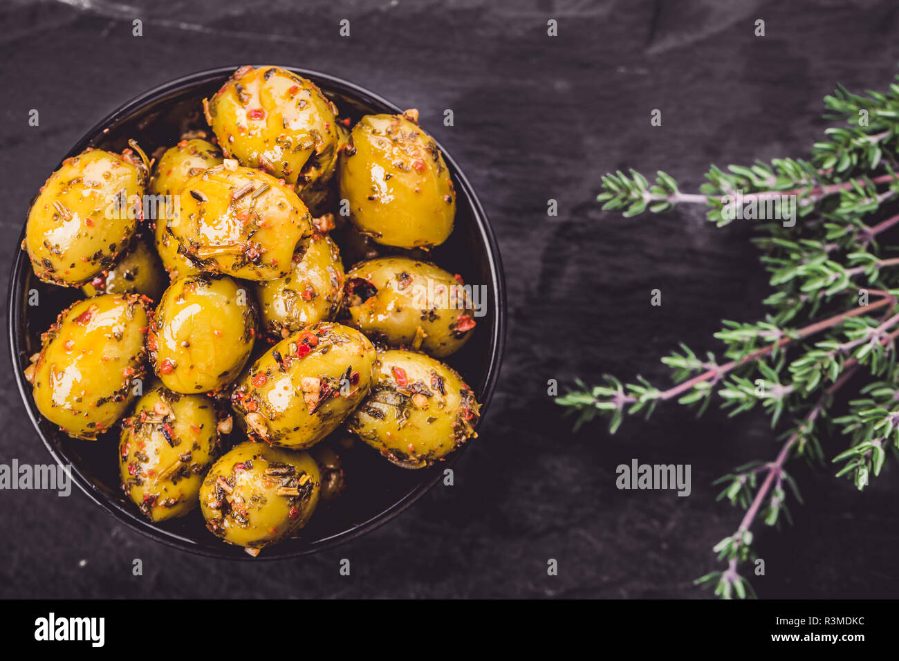 Olive, marinato con erbe aromatiche fresche in olio Foto Stock