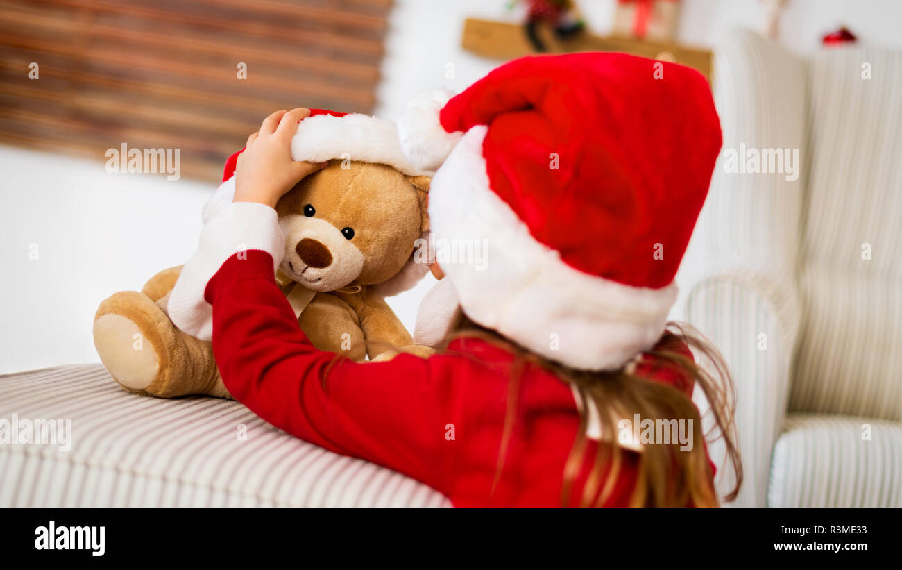Orsetti Di Natale Immagini.Carino Giovane Ragazza Indossando Santa Hat Giocando Con Il Suo Regalo Di Natale Peluche Orsetto Di Peluche Capretto Felice Con Il Natale Presente Foto Stock Alamy