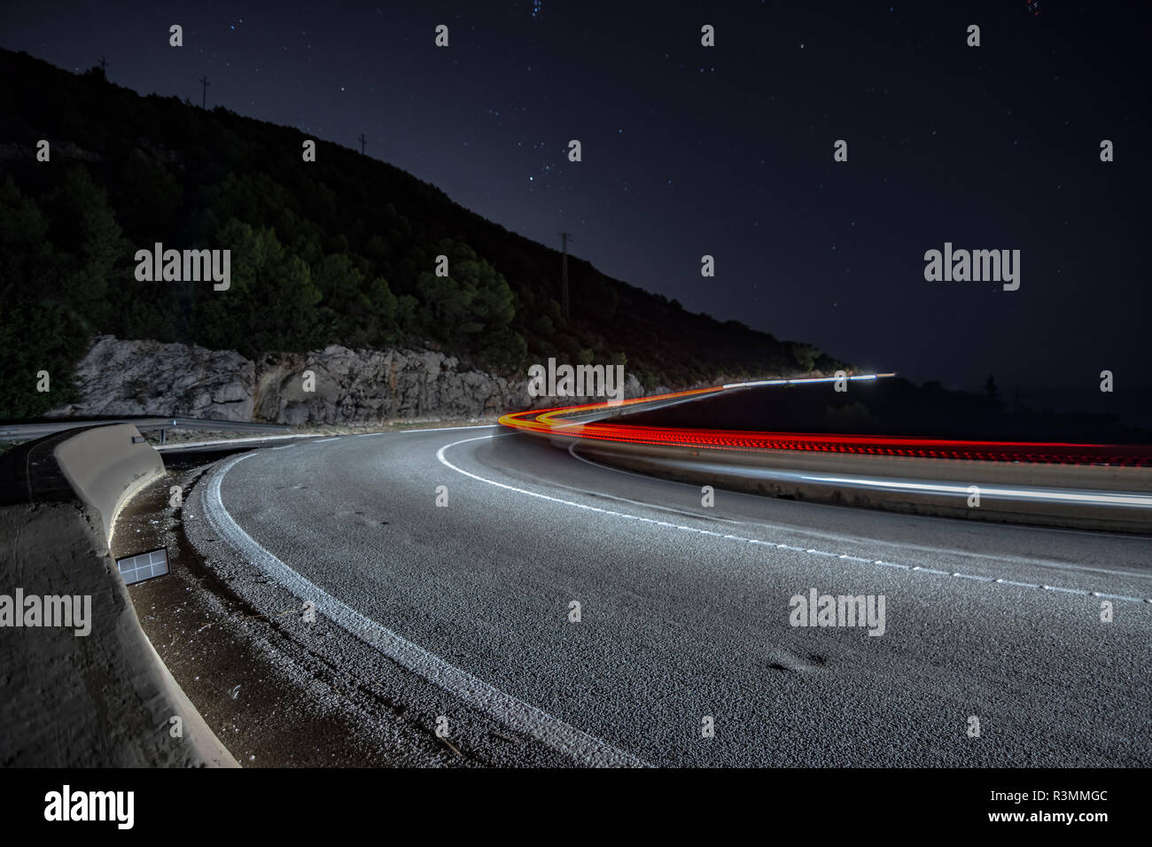 Coches circulando de noche por la carretera de curvas en Cataluña Foto Stock