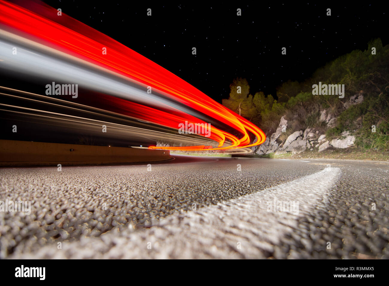 Coches circulando de noche por la carretera de curvas en Cataluña Foto Stock