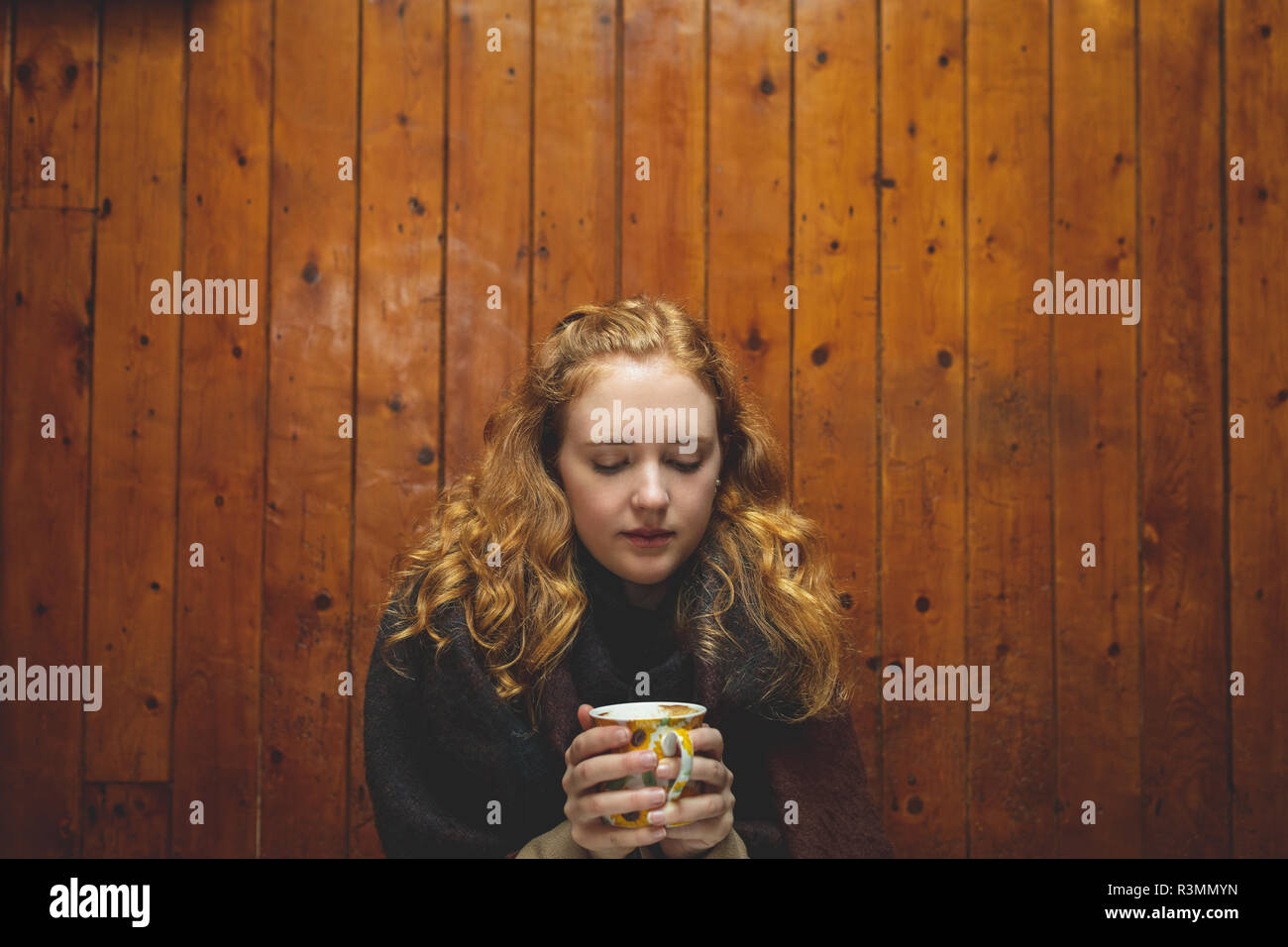 Donna che mantiene una tazza di caffè nella caffetteria Foto Stock
