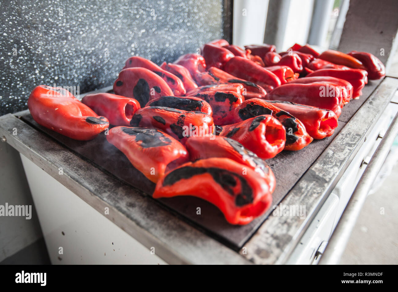 Grigliare i peperoni sulla piastra metallica sulla stufa a legna -  tradizionale preparazione di cibi deliziosi in Serbia Foto stock - Alamy