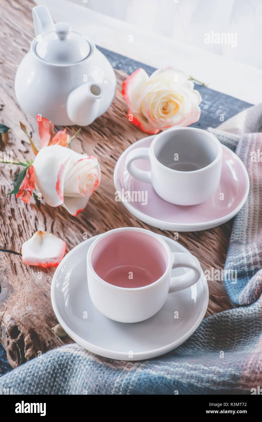 Puro caffè o tè set. Una coppia di raffinata porcellana grigio chiaro e rosa pastello tazze su un sfondo accogliente Foto Stock