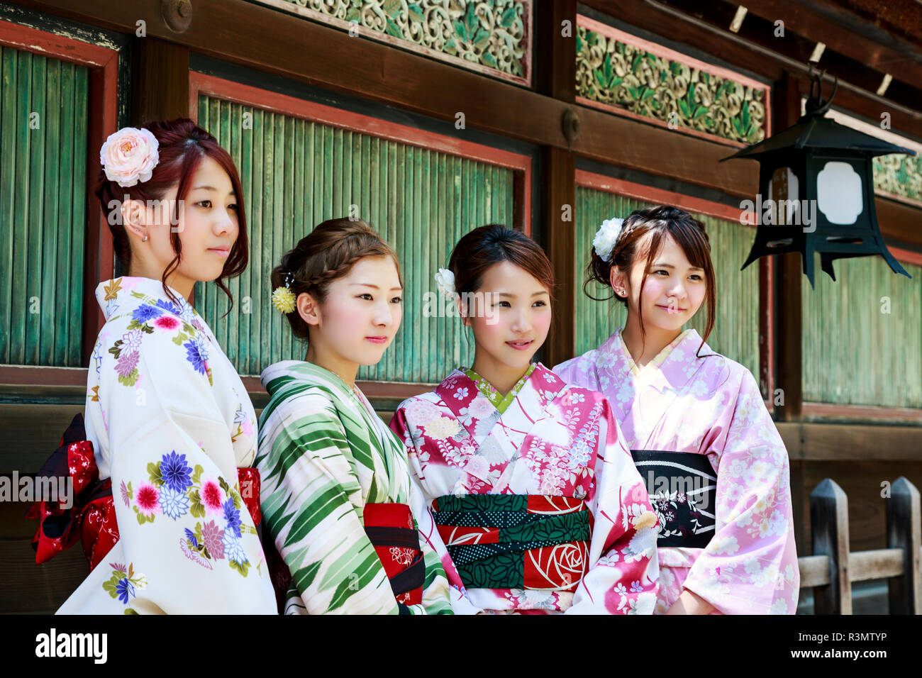 Kyoto, Giappone. Quattro giovani donne vestite in kimono tradizionali presso lo Shinto il santuario Yasaka, Gion-jinja Foto Stock