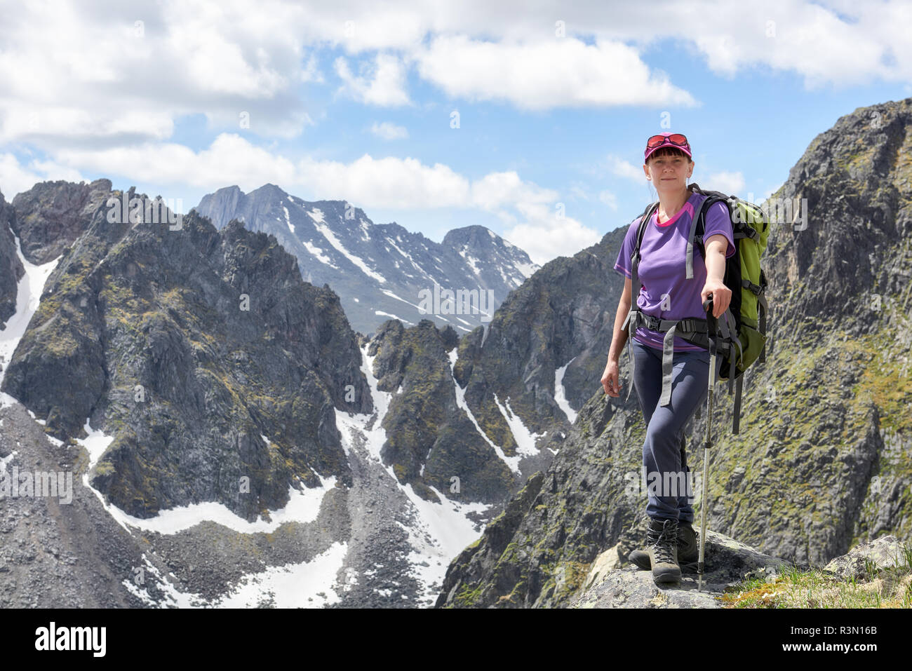 Arrampicata. La donna si erge sul bordo del picco di montagna. Attività all'aperto Foto Stock