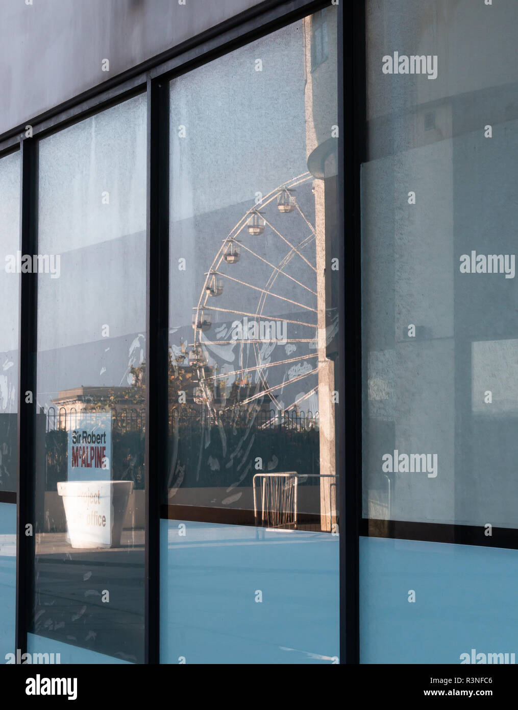 La riflessione di un Ferries Wheel su storefront abbandonati. Foto Stock