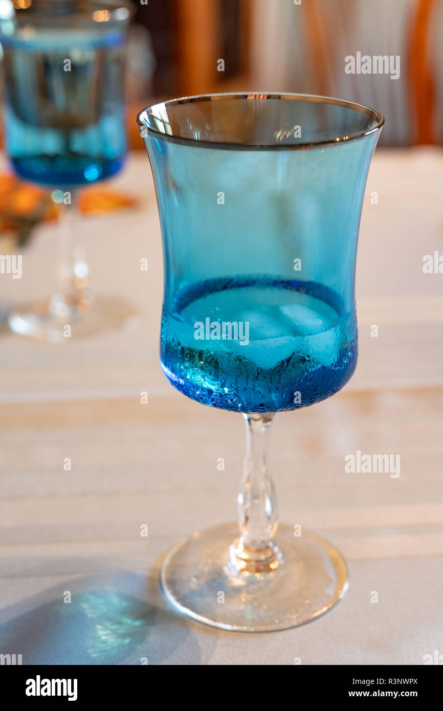 Una luce blu di vetro con acqua e ghiaccio in esso Foto Stock