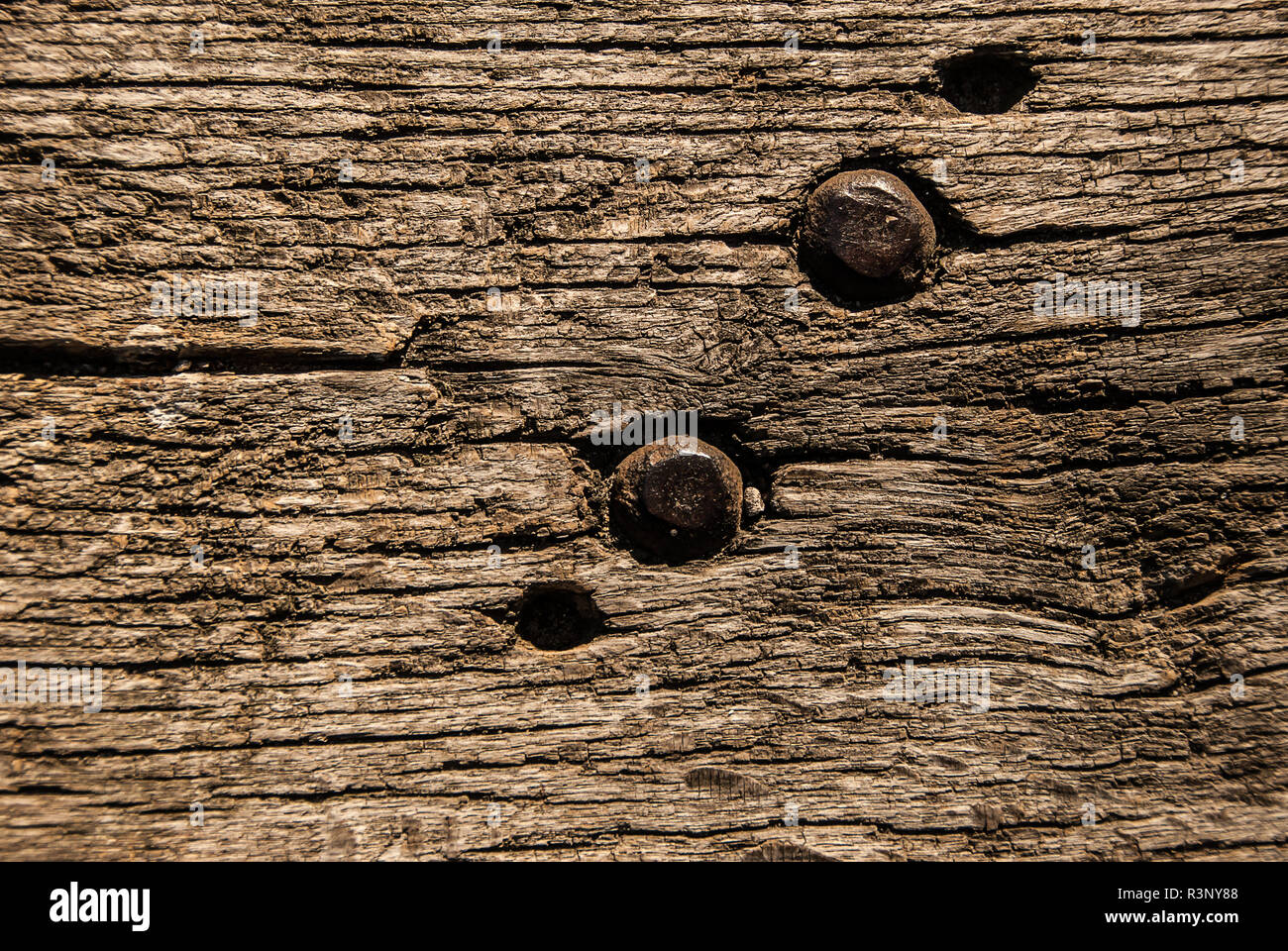 Vecchia panca di legno texture con viti in metallo, primo piano. Invecchiato in legno massiccio in stile rustico a tapparelle squallido sfondo marrone. Legno duro scuro legno stagionato superficie. Foto Stock