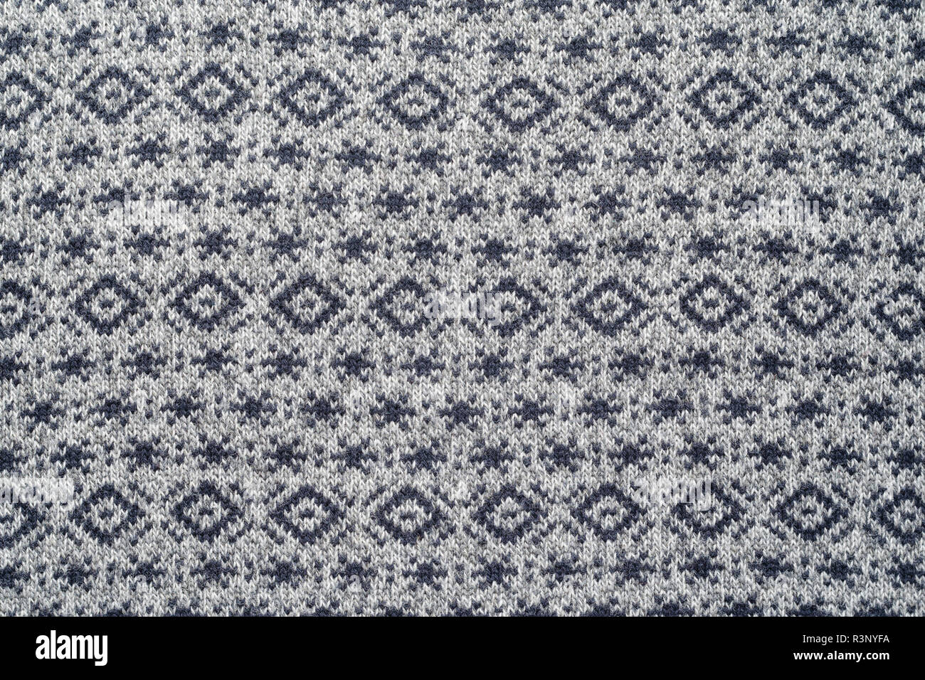 La texture di grigio inverno maglioni con ripetizione di motivi geometrici e piccoli fiocchi di neve. Foto Stock
