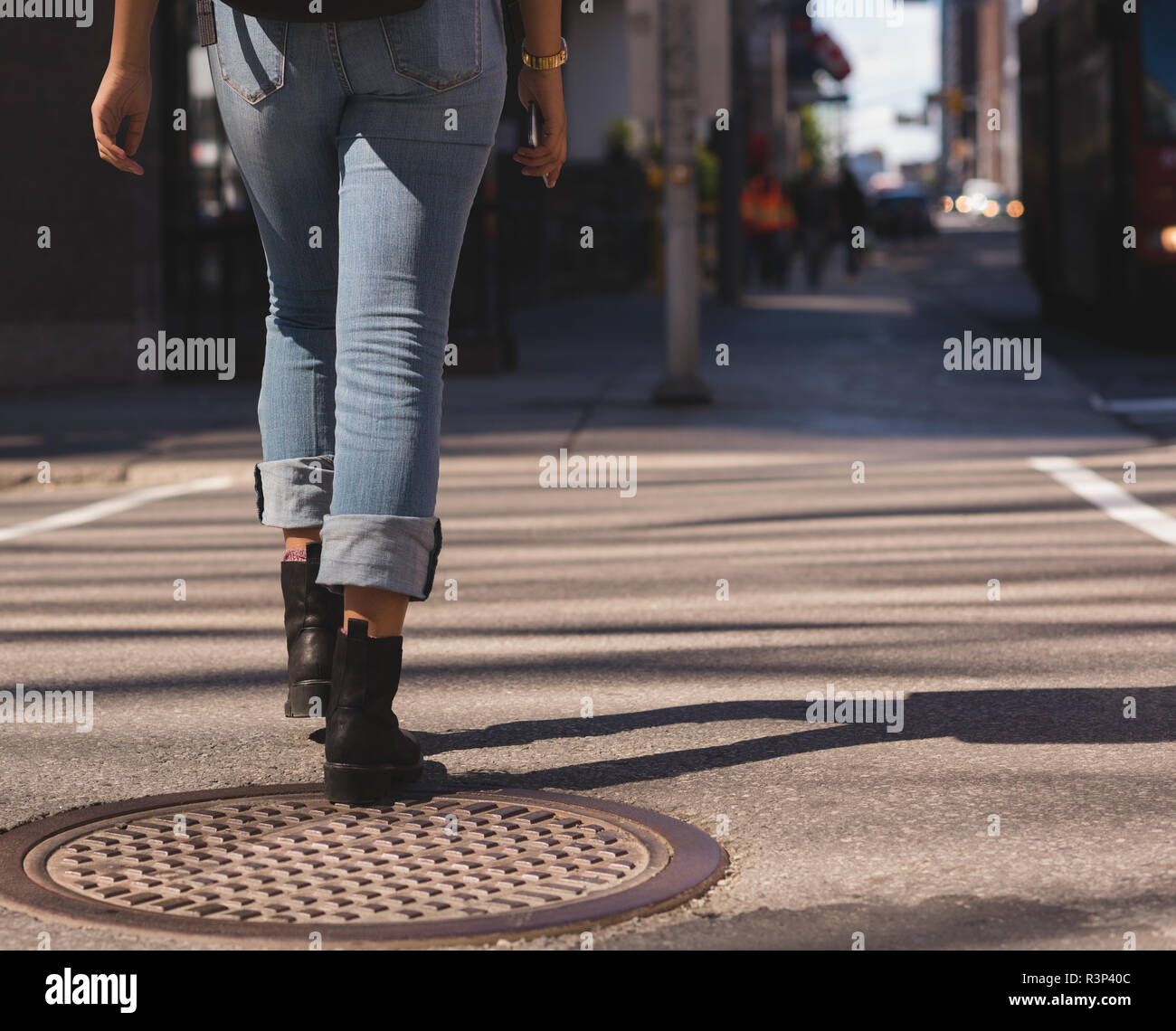 La donna a camminare in città in una giornata di sole Foto Stock