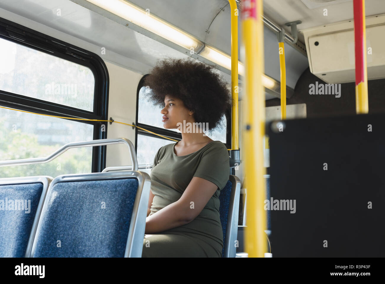 Donna che guarda attraverso la finestrella in bus Foto Stock