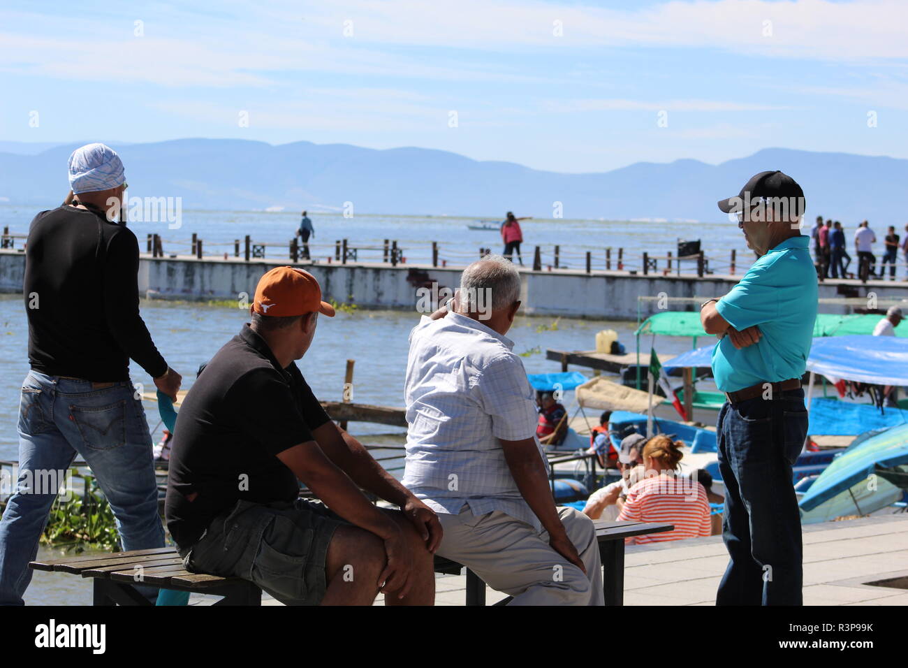 Foto tomada en el malecón del lago de chapala en n.a. tarde soleada en donde se aprecian unos amigos observando el muelle del lago Foto Stock