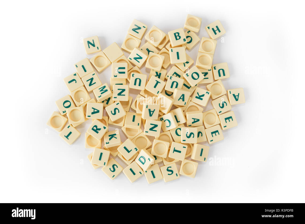 Pila di casuale gioco SCRABBLE lettera di piastrelle con valore di punteggio miscelati, visto dal di sopra, isolato su sfondo bianco. Foto Stock