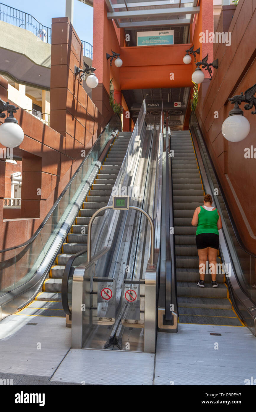 Una persona comune e carrello (o carrello) escalator in Horton Plaza Mall, San Diego, California, Stati Uniti, Foto Stock