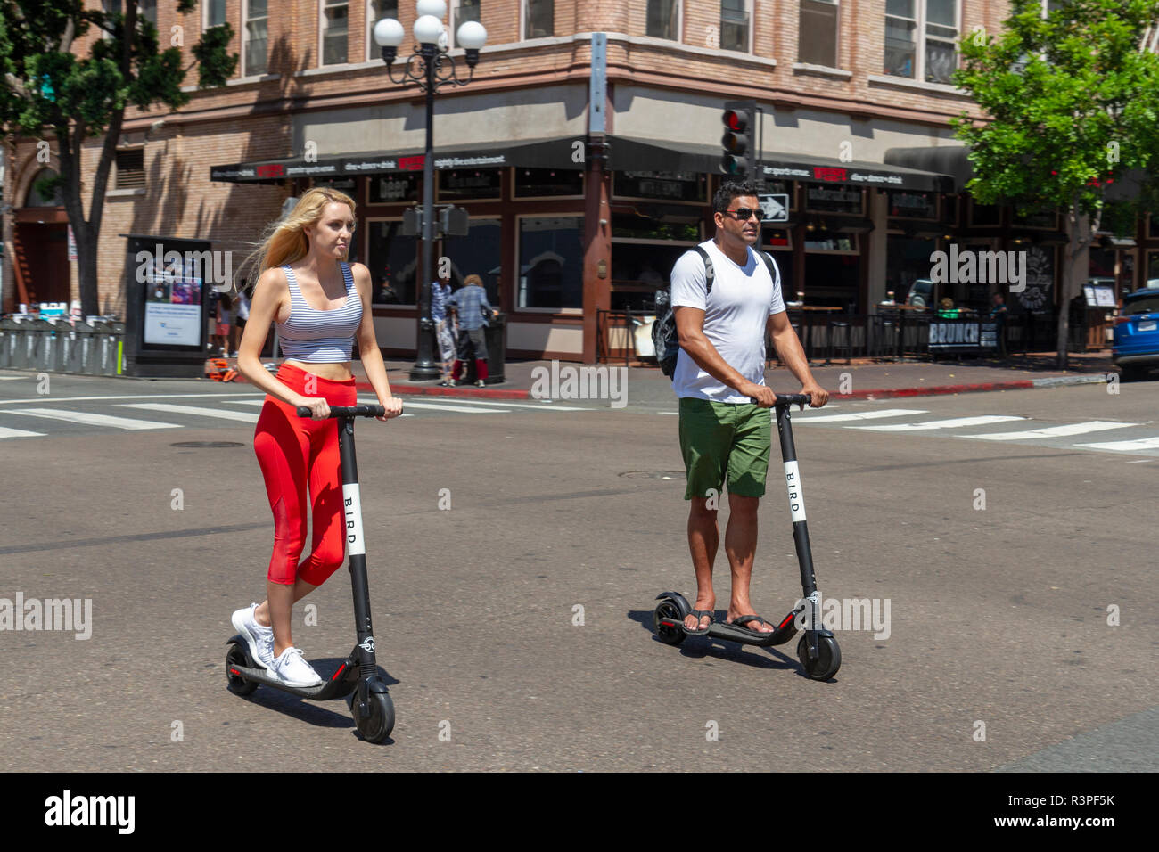 Due persone a cavallo "Bird" scooter elettrici sulla strada a San Diego, California, Stati Uniti. Foto Stock