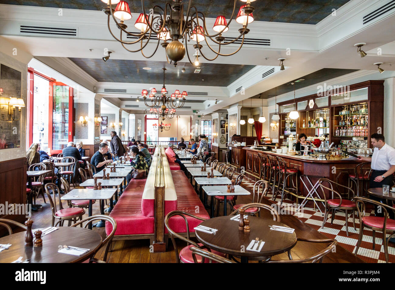 City of London England,UK Cafe Rouge,ristorante ristoranti ristorazione caffè, bistrot francese, bar lounge pub, interno, tavoli, lampadario, uomo Foto Stock