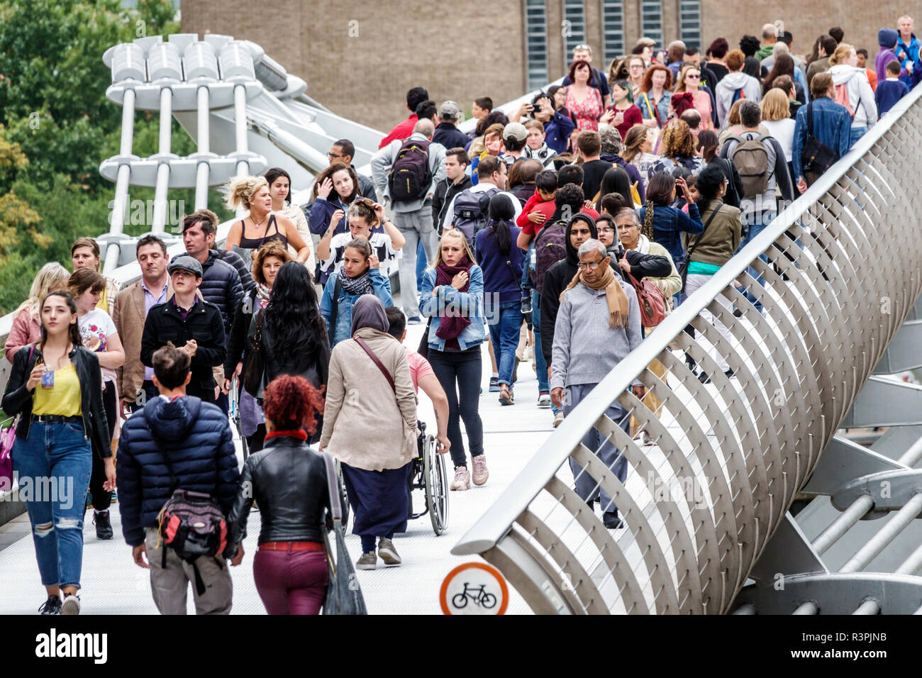 Londra Inghilterra,UK,Millennium Bridge,sospensione in acciaio,passerella,attraversamento pedonale Tamigi River,affollato,multietnico,uomo uomo maschio,donna f Foto Stock