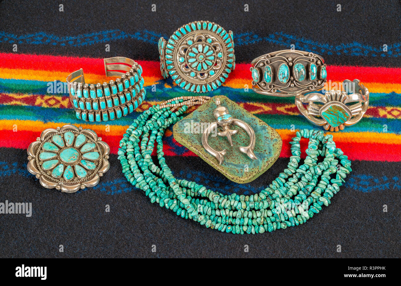 Collezione di gioielleria dei Nativi americani su un colorato sfondo tessili. Il turchese e Sterling Silver Necklace, Bracciali Ciondoli e. Foto Stock