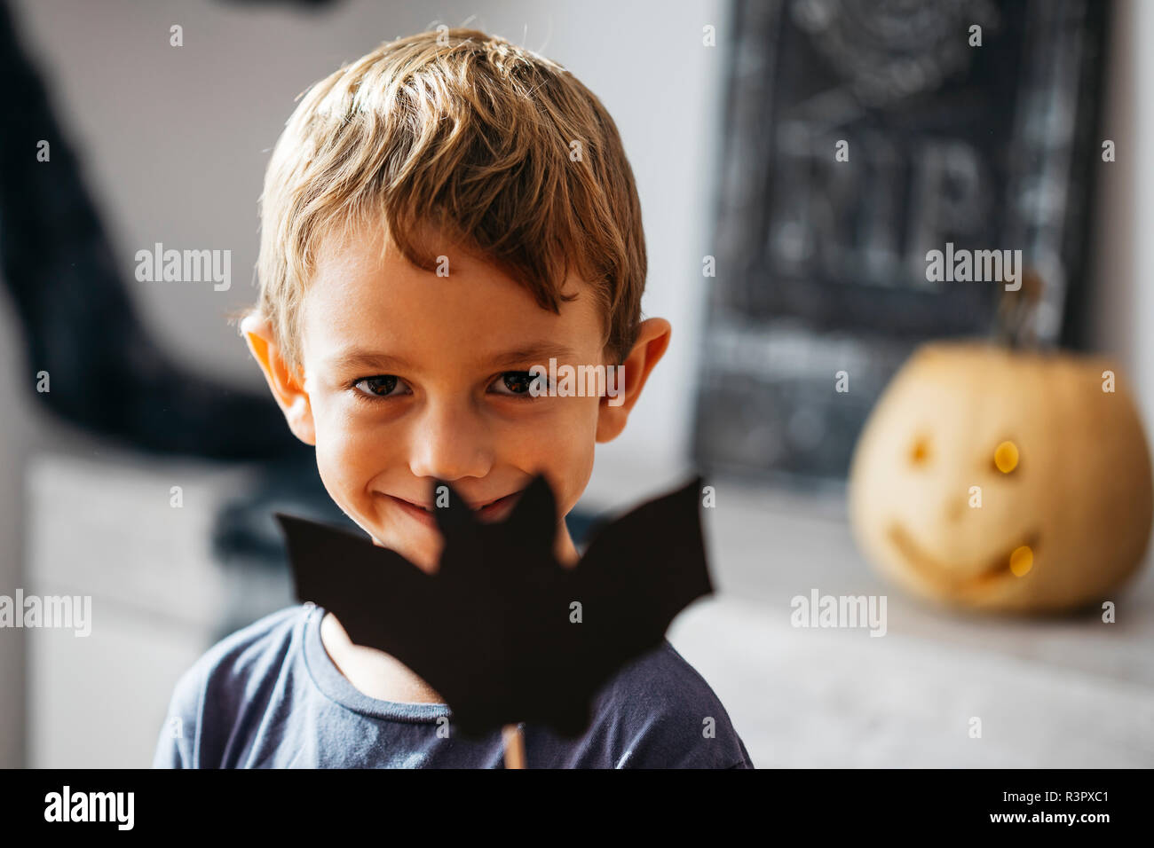Ritratto di sorridente ragazzino con cartone bat Foto Stock