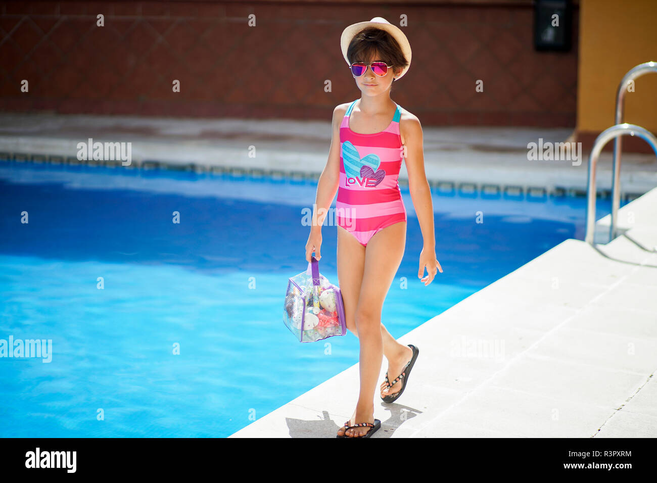 Giovane ragazza che arrivano presso la piscina in estate con bagno vestiti  Foto stock - Alamy