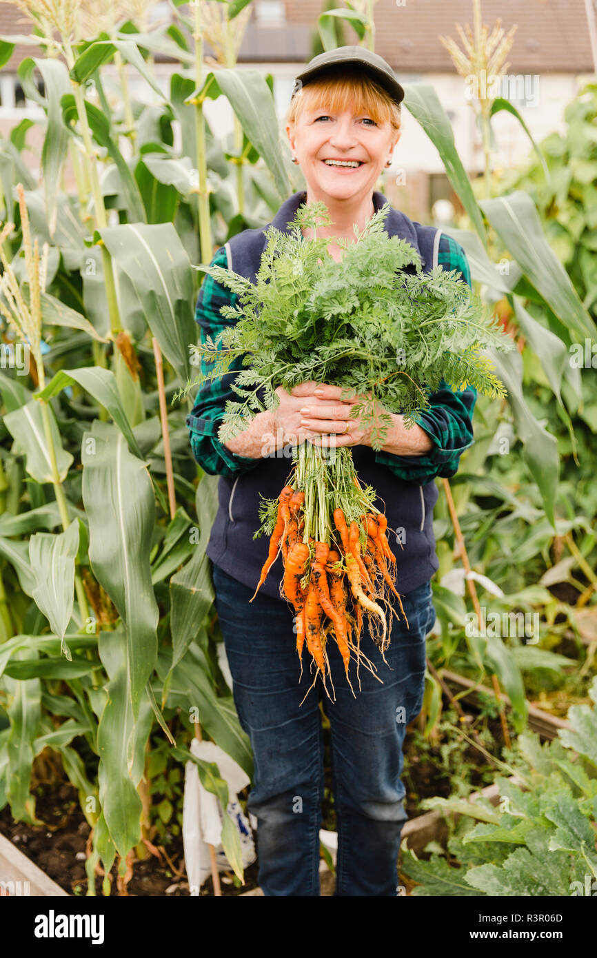 Senior donna azienda appena raccolto le carote dal riparto Foto Stock