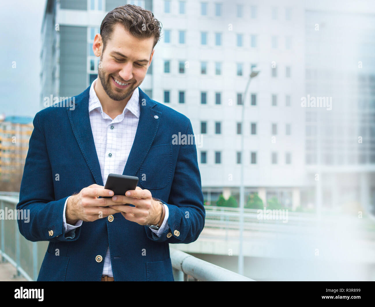 Un felice uomo di successo scrive un messaggio al suo business partner. Foto Stock