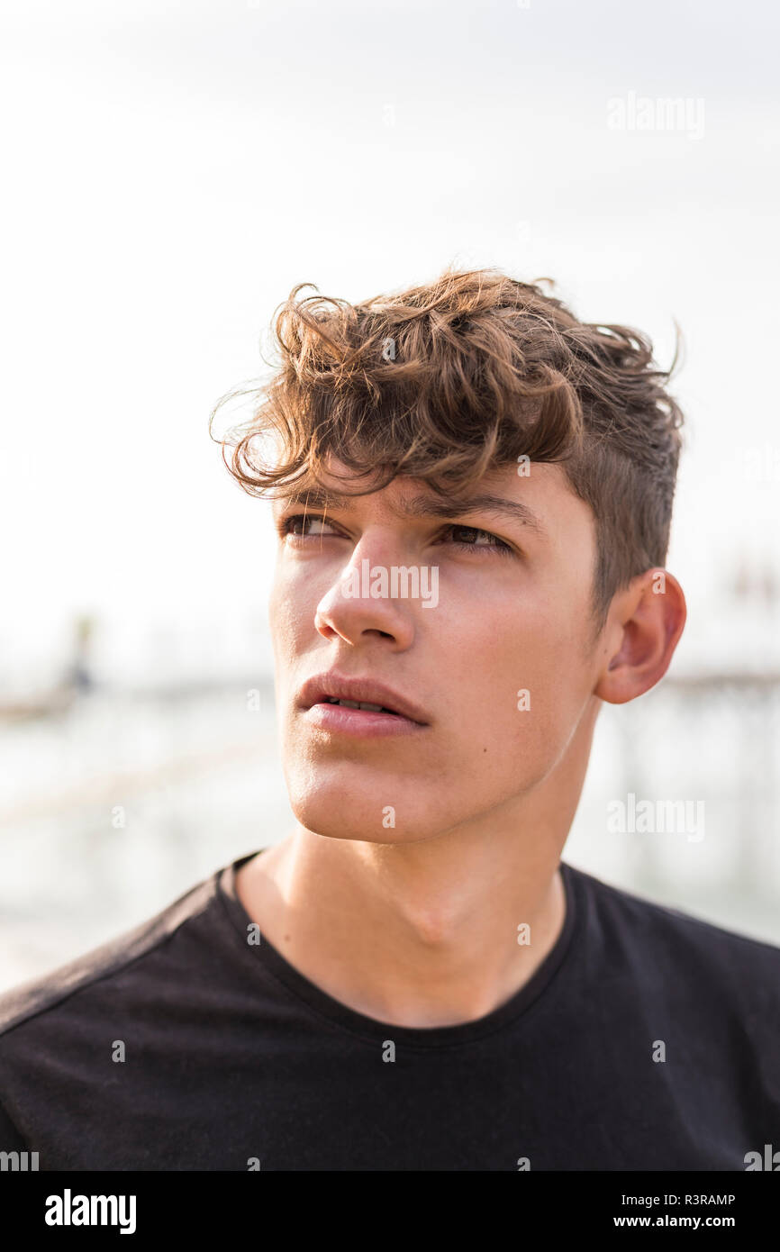 Ritratto di giovane uomo sulla spiaggia per guardare qualcosa Foto Stock