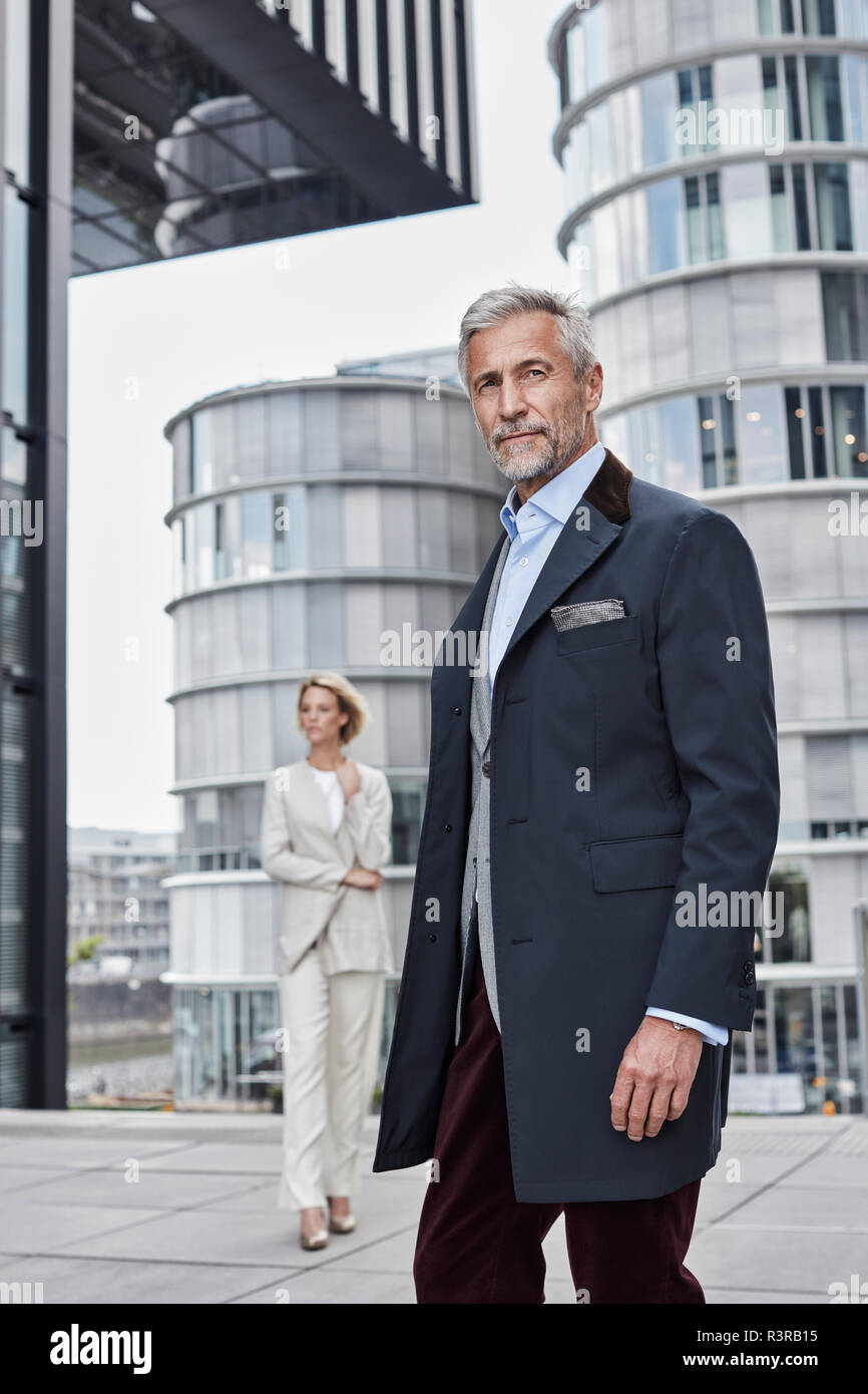 Germania, Duesseldorf, ritratto di moda imprenditore maturo nella parte anteriore del moderno edificio aziendale Foto Stock