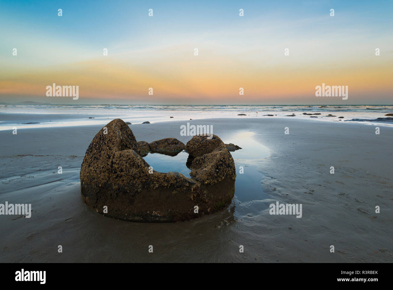Nuova Zelanda, costa Otago, Moeraki Boulders Koekohe sulla spiaggia con cielo a sunrise Foto Stock