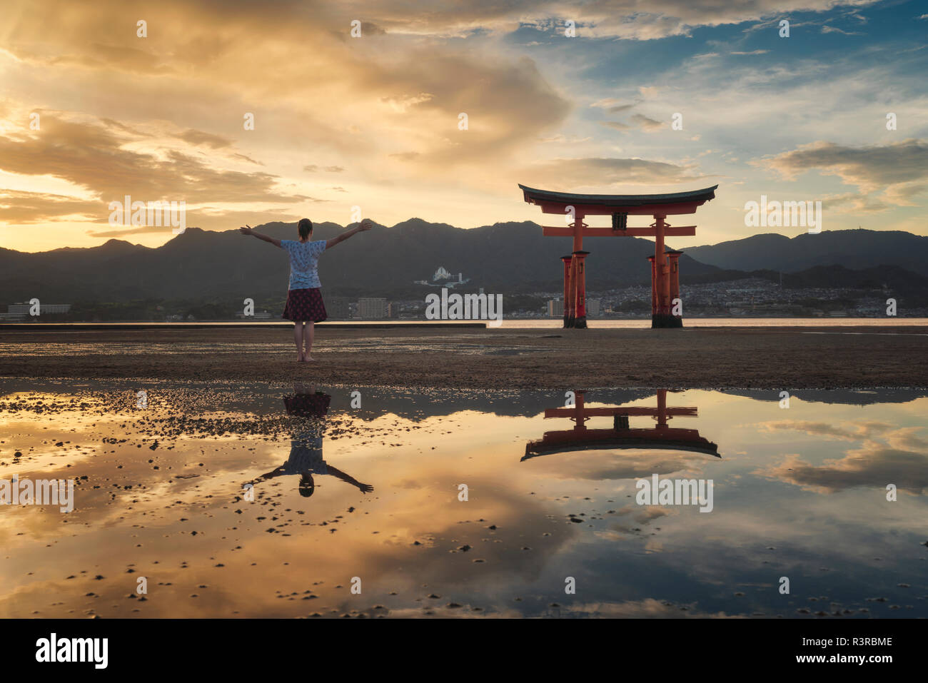 Donna godendo il tramonto sull'isola di Itsukushima o Miyajima, Hiroshima, Giappone Foto Stock